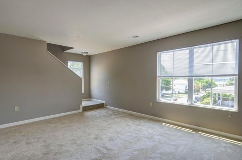 the living room of an empty house with a large window