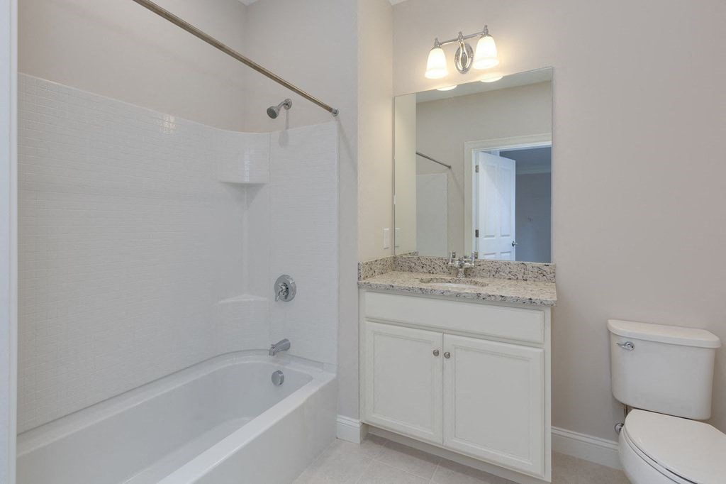 a white bathroom with a tub and a sink