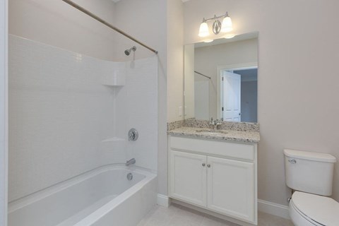 a white bathroom with a tub and a sink