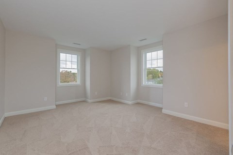 the living room of an empty house with two windows