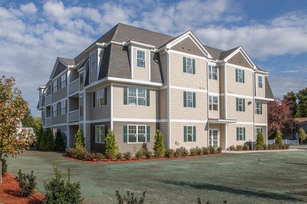 a large apartment building with a yard in front of it