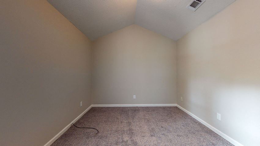 a empty room with a carpeted floor and white walls