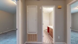 an empty living room with a door and a kitchen