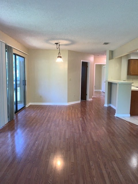 A room with wooden flooring and a ceiling light.