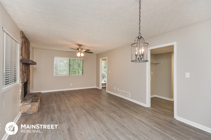 the living room and dining room with wood flooring and a ceiling fan