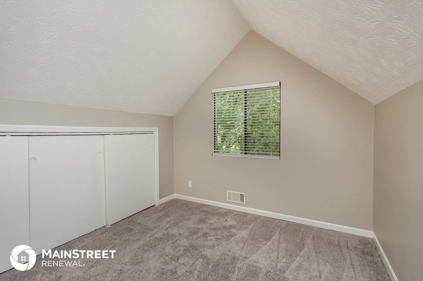 the upstairs bedroom with closet and window