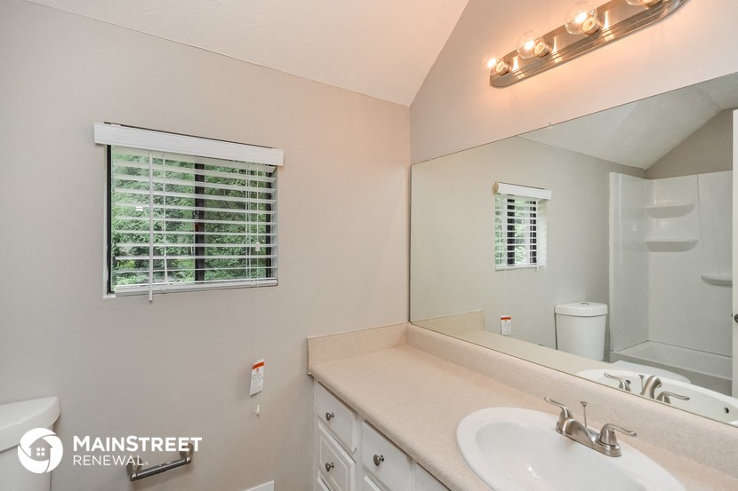 the bathroom has a large mirror and a sink