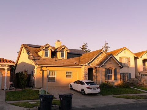 A white car is parked in front of a house.