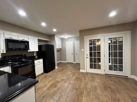 A kitchen with black countertops and white cabinets.