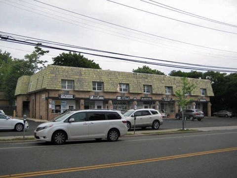 a building with a roof and cars parked in front of it