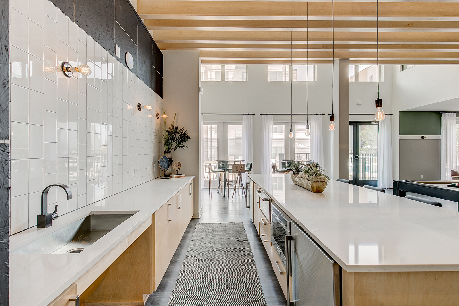 a large kitchen with white counters and white tiled walls