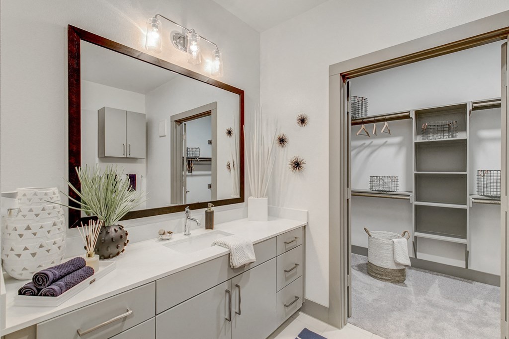 a white bathroom with a large mirror and a closet