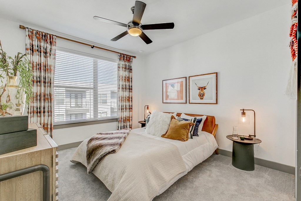 a bedroom with a bed and a ceiling fan