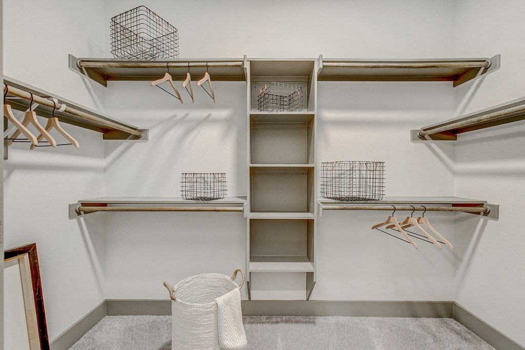 a walk in closet with shelves and baskets and a roll of toilet paper
