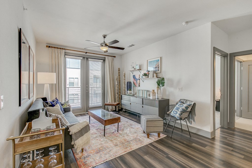 a living room with a ceiling fan and a large window