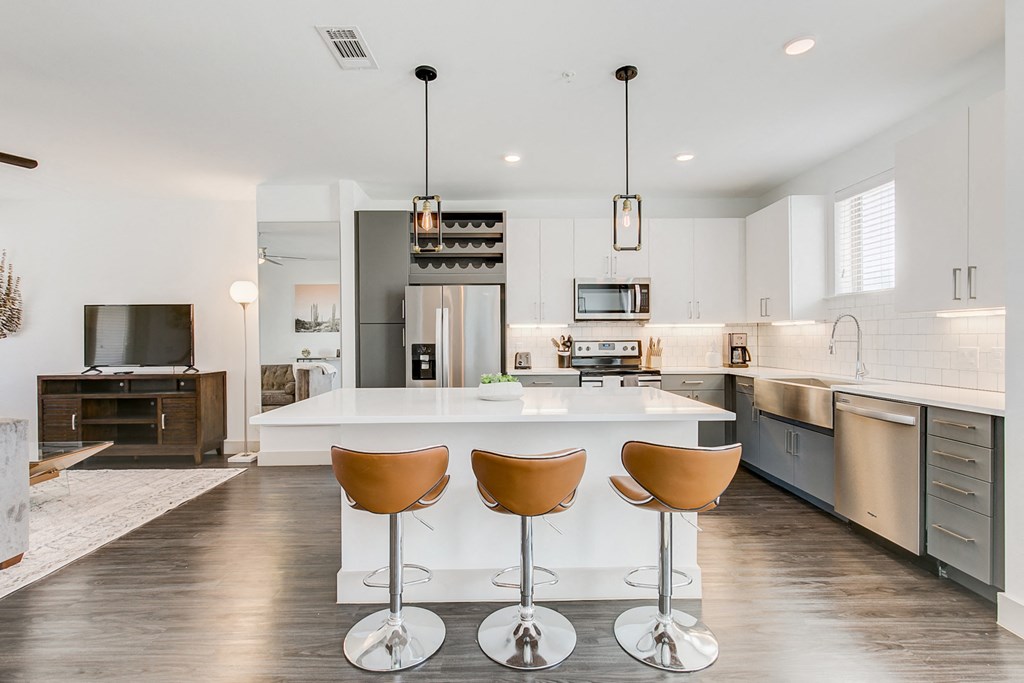 a large kitchen with a white island with four chairs