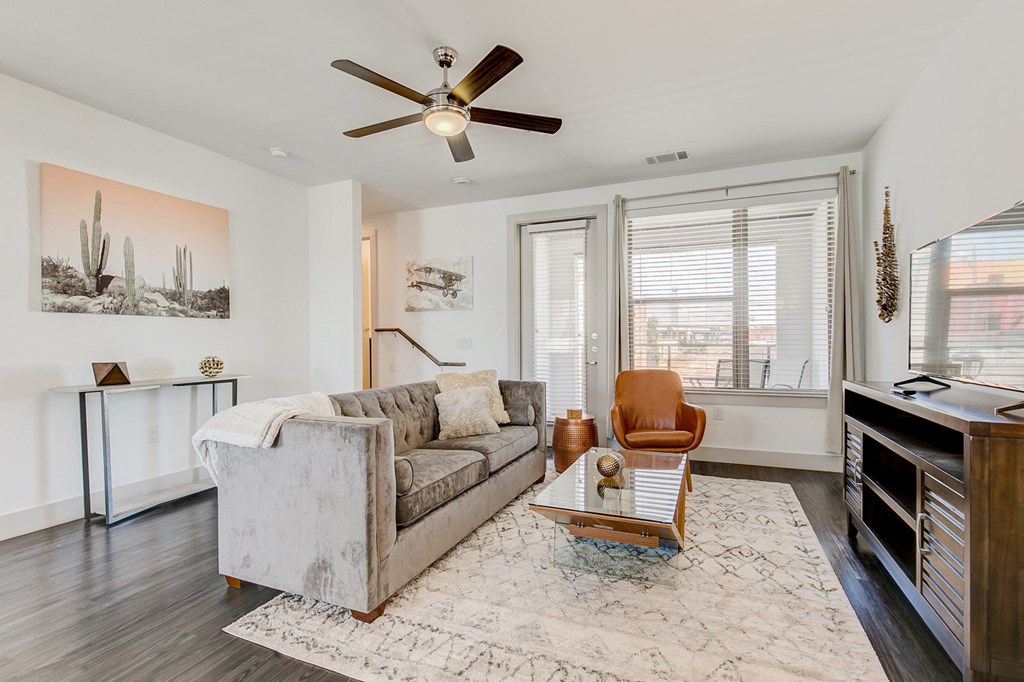 a living room with a couch and a ceiling fan