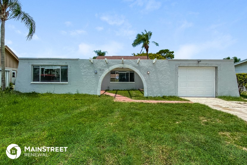 a light blue house with a yard and a garage door