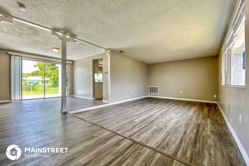 an empty living room with wood floors and a sliding glass door