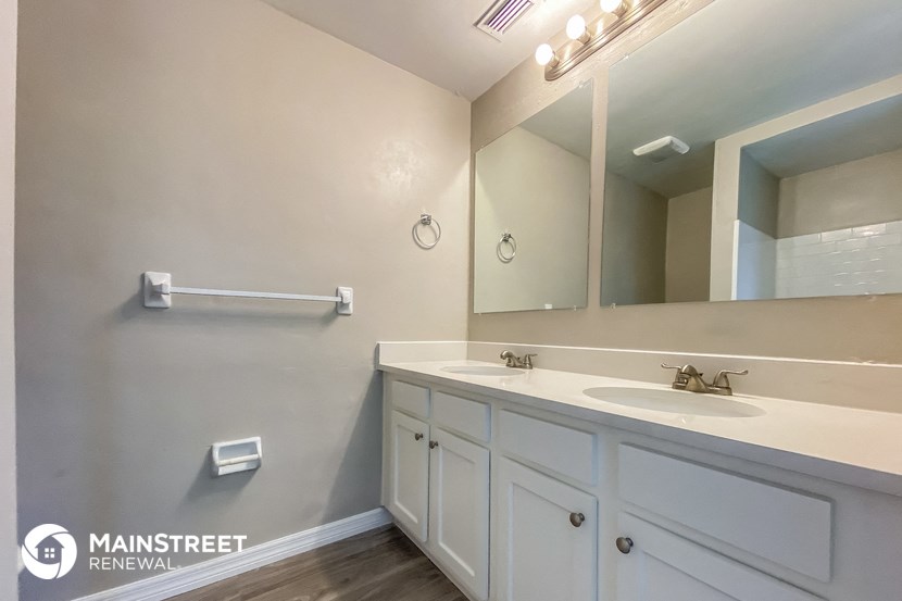 a bathroom with white cabinets and a sink and a mirror