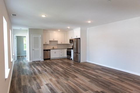 A kitchen with white cabinets and a refrigerator.