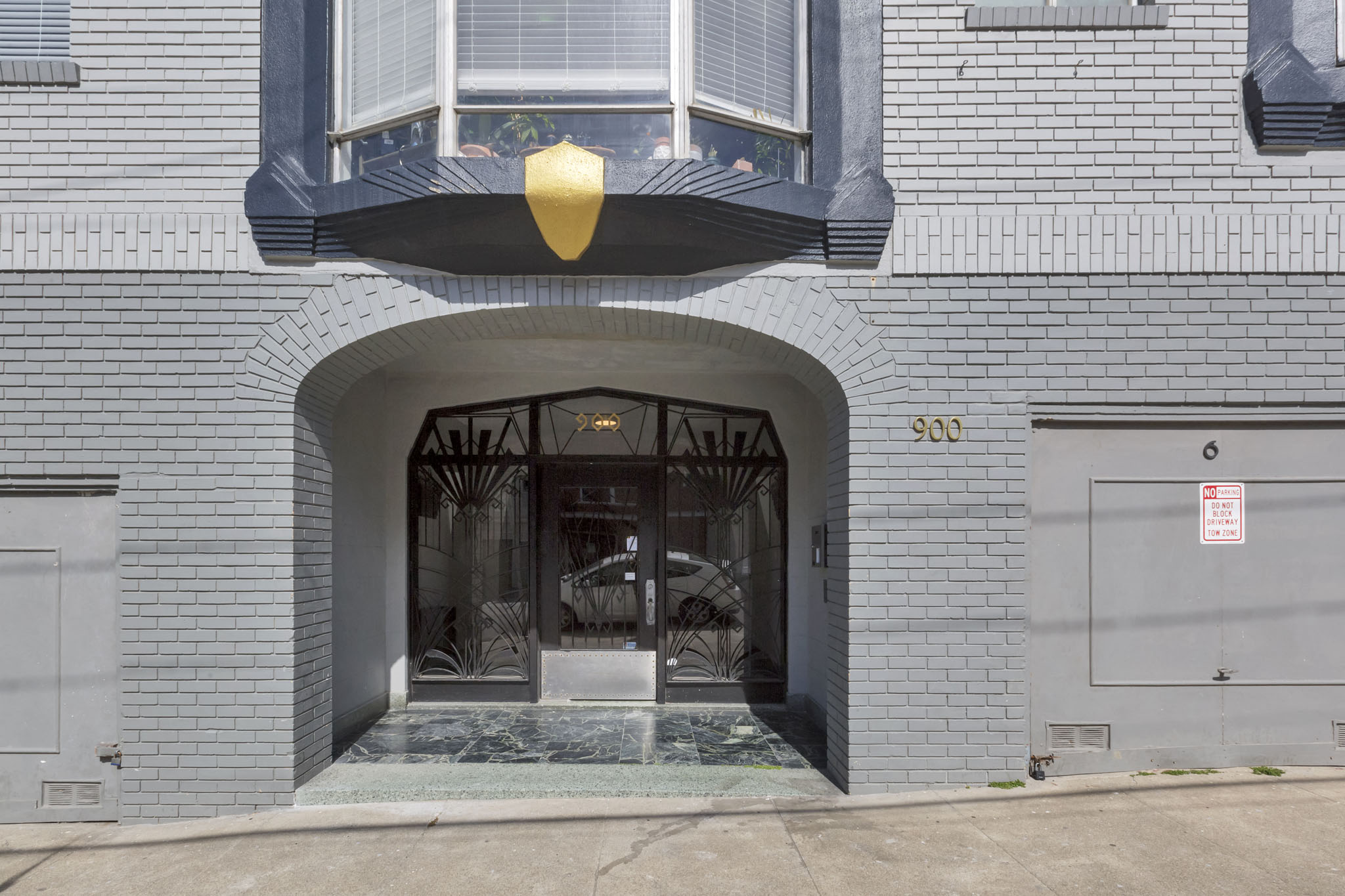 A grey building with a black awning and a sign that says 900.