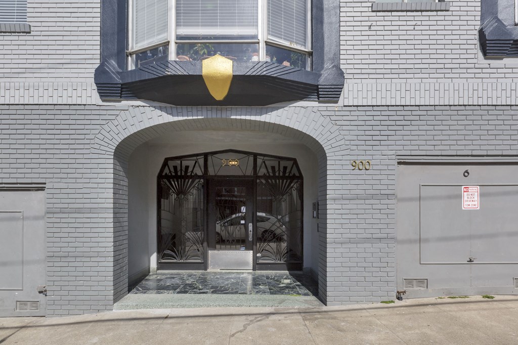 A grey building with a black awning and a sign that says 900.