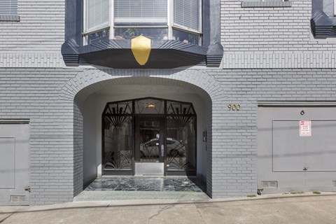 A grey building with a black awning and a sign that says 900.