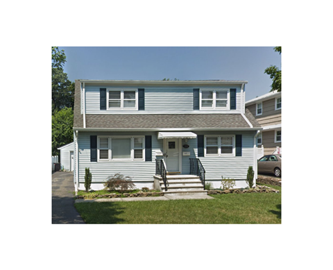 A two-story house with a grey roof and white siding.