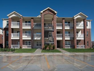 an exterior view of an apartment building with a parking lot