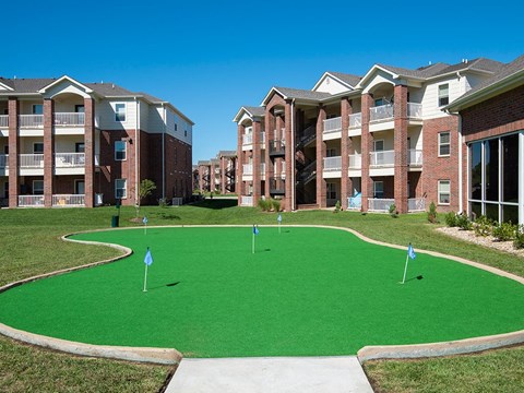 a putting green in front of an apartment building