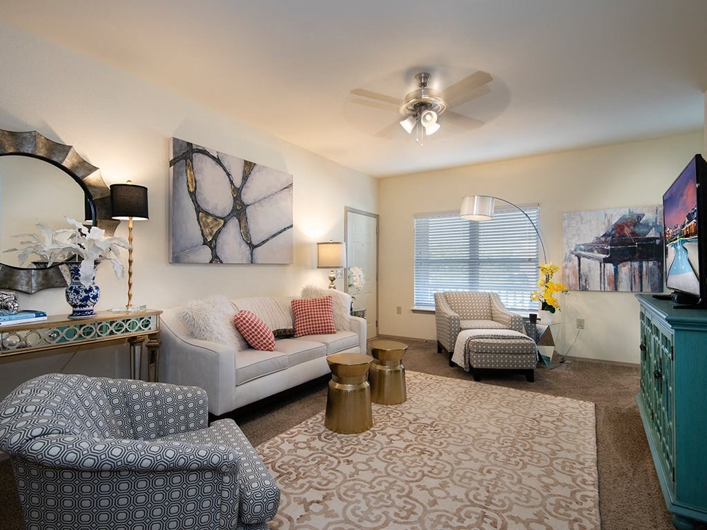 a living room with furniture and a ceiling fan