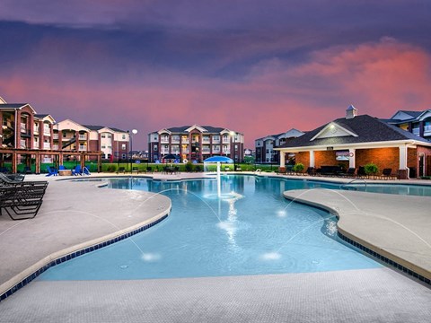 a large swimming pool with apartments in the background