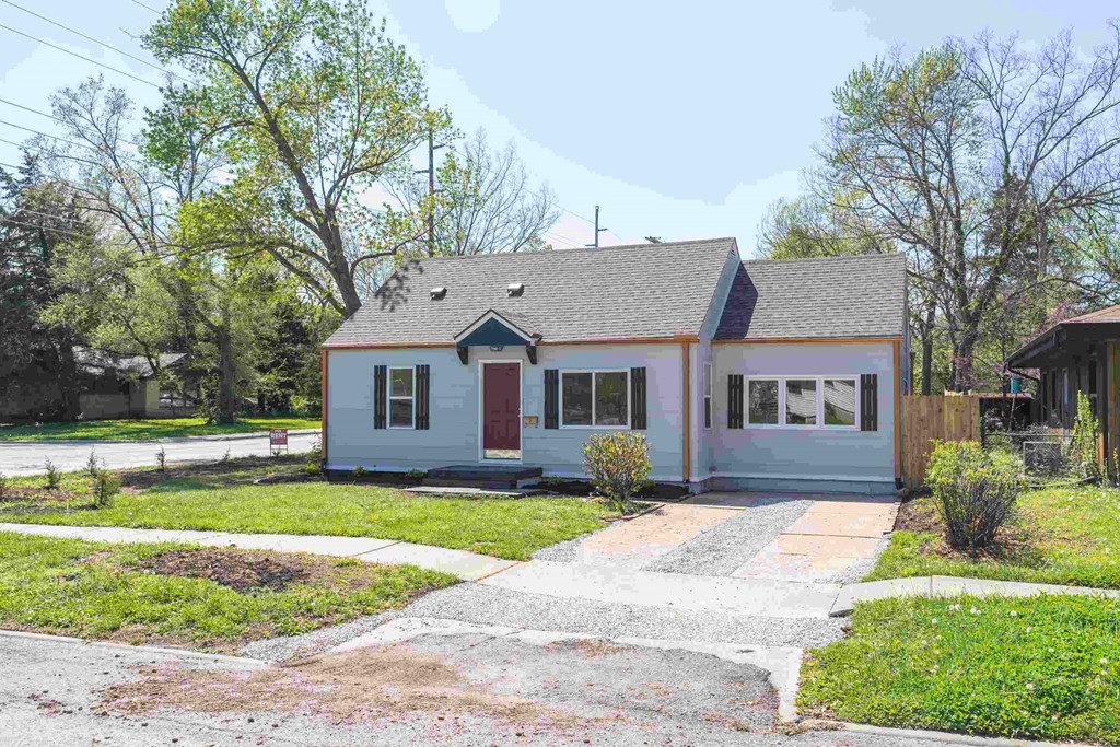 A small house with a red door and a grey roof.