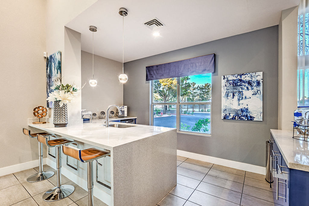 A kitchen with a white counter and bar stools.