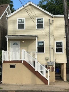 A house with a white front porch and brown stairs.