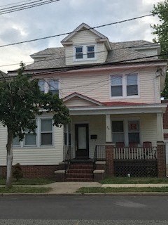 A two-story house with a front porch and a small front yard.
