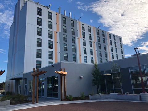 A modern building with a grey and orange facade.