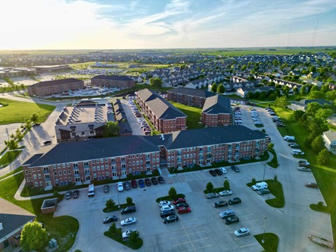 A large red brick building with a parking lot in front.