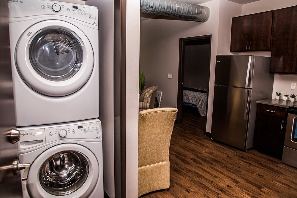 a washer and dryer in a living room next to a kitchen