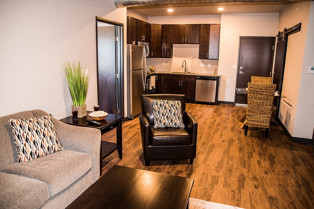 a living room and kitchen with a couch and a table