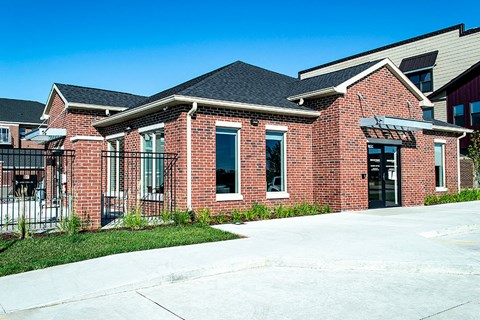 the front of a brick building with a sidewalk in front