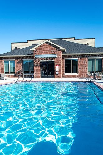 a large swimming pool in front of a brick building