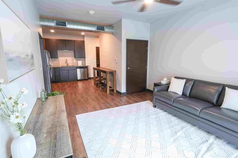 A modern living room with a grey couch and a wooden table.