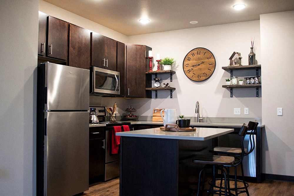 a kitchen with stainless steel appliances and a clock on the wall