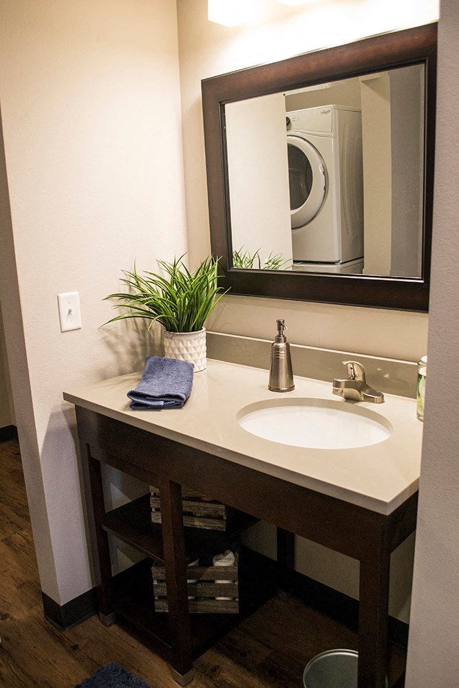 a bathroom with a sink and a mirror and a washing machine