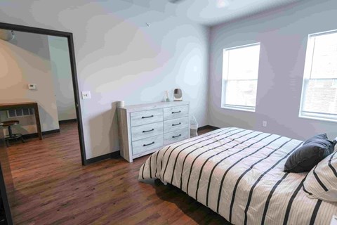 A bedroom with a bed, dresser, and mirror.