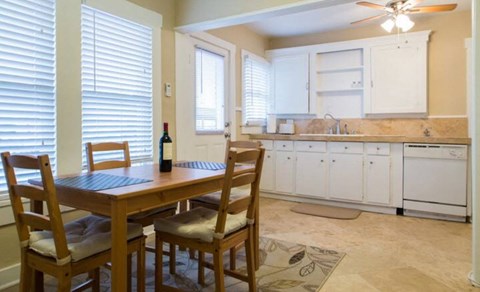 A dining room with a wooden table and chairs.