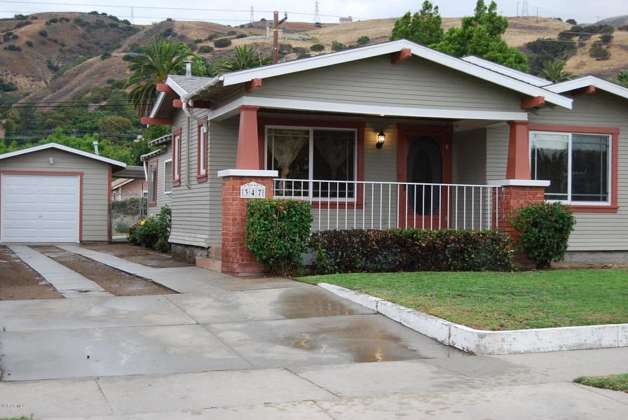 a house with a porch and a sidewalk in front of it