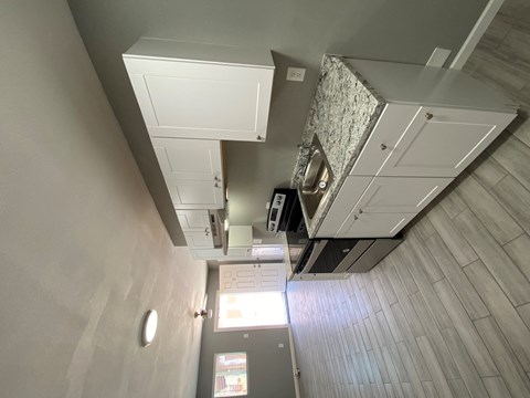 A view of a room with a ceiling fan and a light fixture.